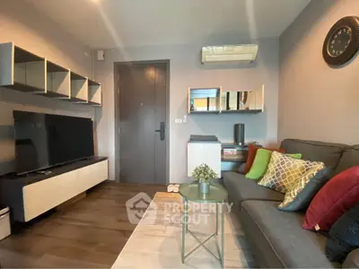 Modern living room with stylish decor and wall-mounted TV, featuring cozy seating and elegant shelving.