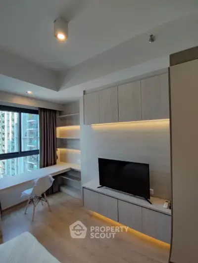 Modern bedroom with built-in TV unit and study desk, featuring large window with city view.