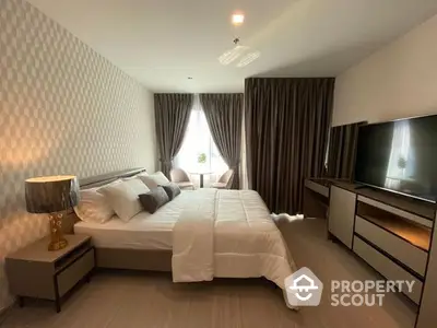 Spacious and elegantly furnished bedroom with a large bed, modern TV unit, and ambient lighting, perfect for relaxation and comfort.