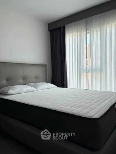 Modern bedroom with large window and stylish bed in a contemporary apartment.