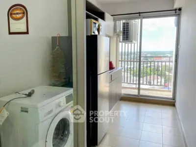 Modern apartment with balcony view and laundry area featuring washing machine and fridge.