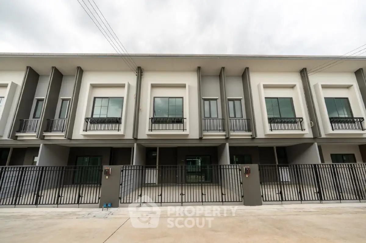 Modern townhouse exterior with sleek design and gated entrance