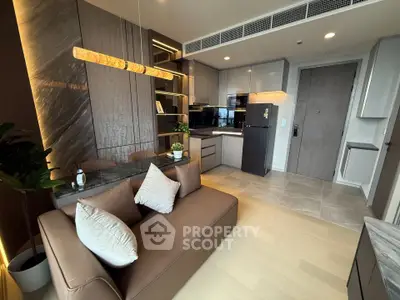 Modern open-layout kitchen and living room with stylish decor and cozy seating area.
