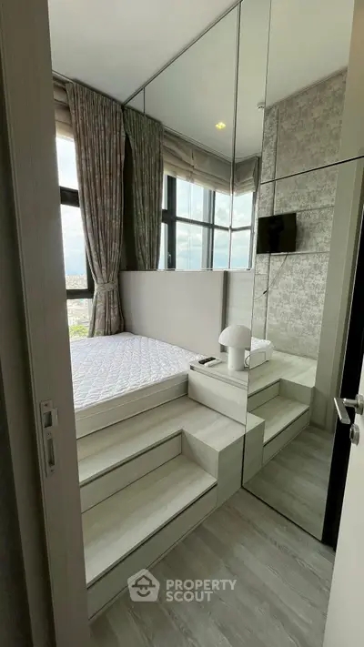 Modern bedroom with mirrored walls and elevated bed platform