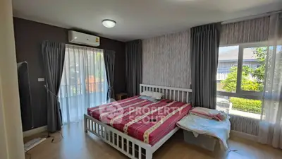 Spacious bedroom with large windows and modern decor, featuring a comfortable bed and natural light.