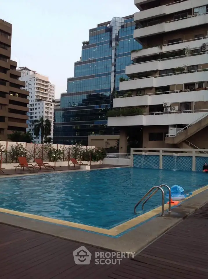 Luxurious residential pool area with modern high-rise buildings in the background, perfect for relaxation.