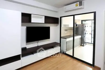 Modern living room with sleek TV unit and view into contemporary kitchen