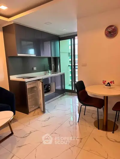 Modern kitchen with sleek cabinetry and dining area in a stylish apartment