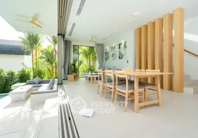 Luxurious open-plan living room with modern decor and seamless indoor-outdoor flow to a lush garden.