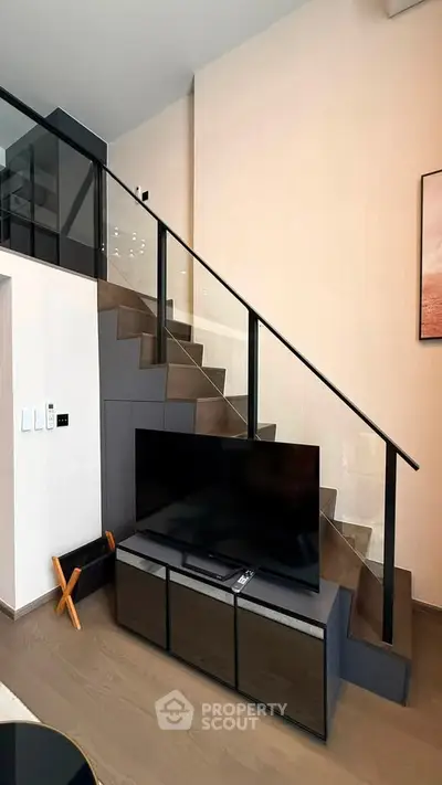 Modern living room with sleek staircase and TV unit, perfect for stylish urban living.
