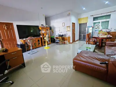 Spacious living room with modern furniture and large TV in a cozy home setting.