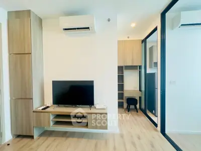 Modern living room with sleek TV setup and mirrored closet doors