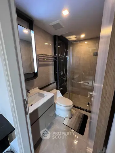 Modern bathroom with sleek design, glass shower, and elegant fixtures in a luxury apartment.