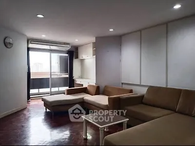 Spacious living room with modern furniture and balcony access in urban apartment.
