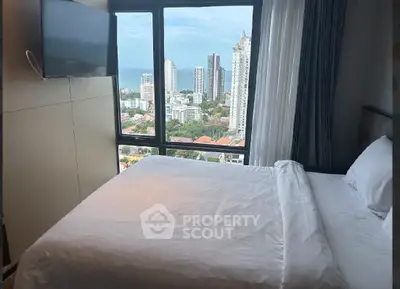 Luxurious bedroom with stunning city and ocean view from high-rise window.