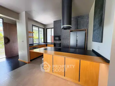 Modern kitchen with sleek design, featuring wooden cabinetry and black countertops, ideal for contemporary living.