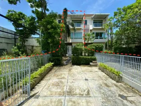 Charming modern building with lush greenery and spacious driveway, perfect for serene living.