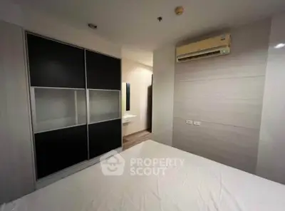Modern bedroom with sleek wardrobe and air conditioning unit, perfect for comfortable living.