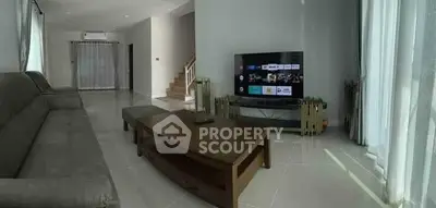 Spacious living room with modern furniture and large TV, perfect for relaxation.