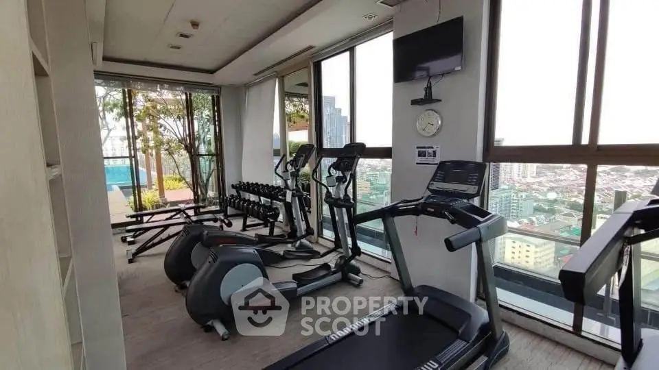Modern gym with city view and state-of-the-art equipment in luxury high-rise building.