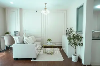 Elegant living room with modern decor, featuring a cozy sofa, chic chandelier, and stylish workspace.