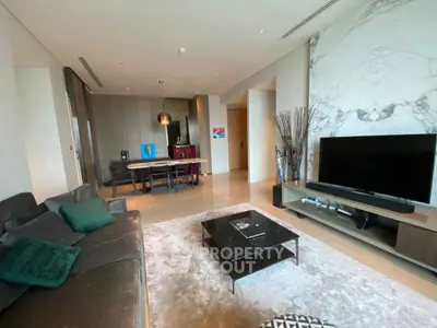 Luxurious living room with modern decor and large TV, perfect for relaxation and entertainment.