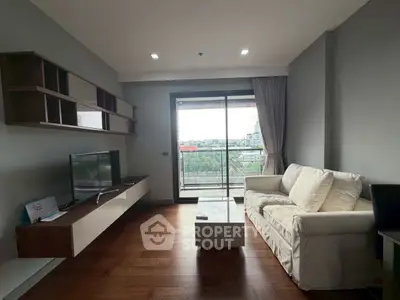 Modern living room with balcony view, sleek furniture, and natural light in a stylish apartment.