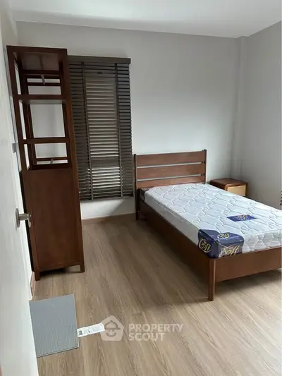 Cozy bedroom with wooden flooring and minimalist furniture