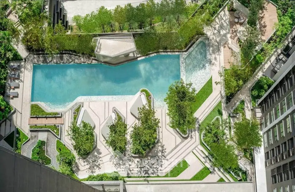Luxurious aerial view of modern apartment complex with stunning pool and lush greenery.