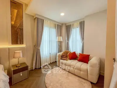 Elegant living room with plush sofa, stylish decor, and natural light through large windows.