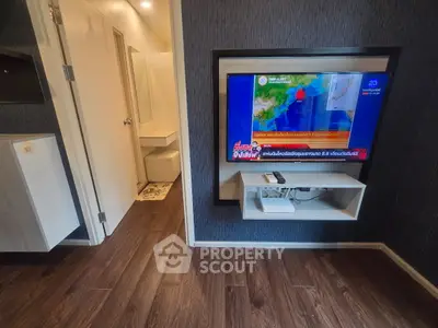 Modern living room with wall-mounted TV and sleek wooden flooring