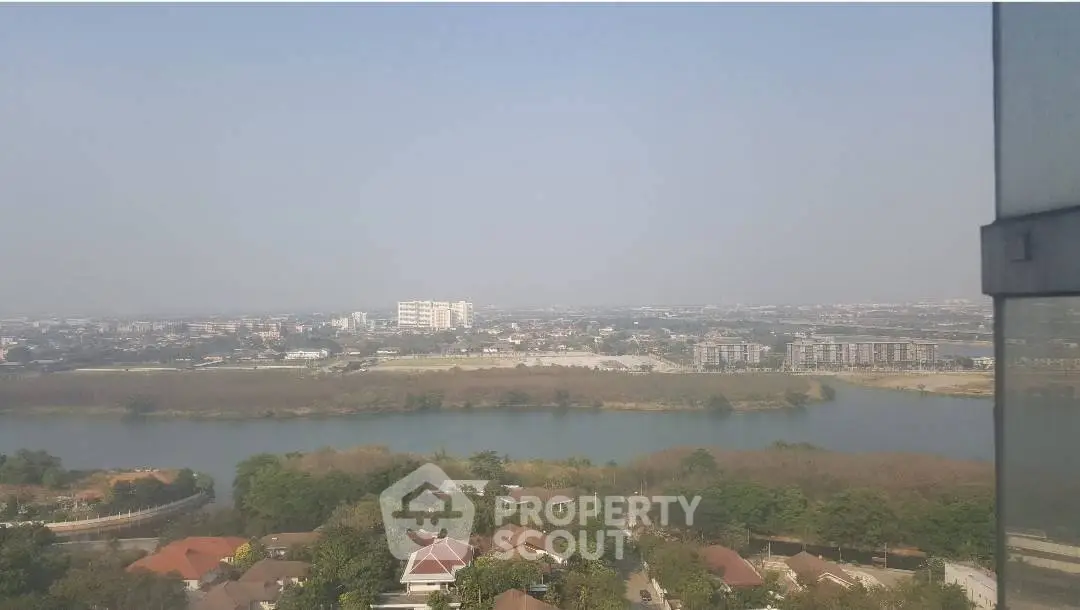 Stunning panoramic view from high-rise apartment overlooking river and cityscape.