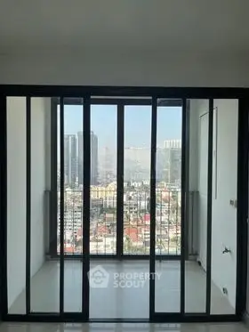 Spacious balcony with stunning city view and floor-to-ceiling glass doors.