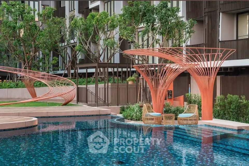 Luxurious modern pool area with artistic structures and lush greenery in a high-end residential complex.
