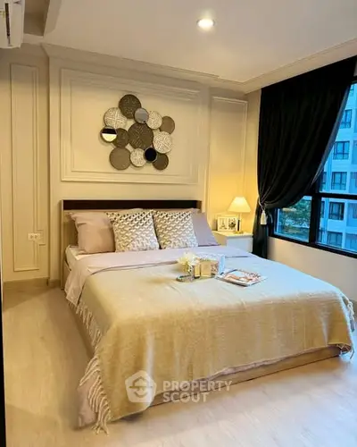 Luxurious bedroom with elegant decor and large window view in modern apartment.