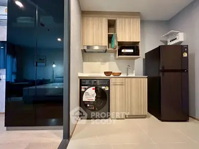 Modern compact kitchen with appliances and sleek cabinetry in stylish apartment.