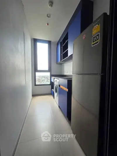 Modern compact kitchen with sleek blue cabinets and appliances