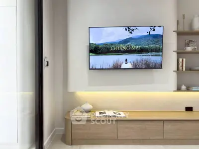 Modern living room with wall-mounted TV and stylish wooden shelving.