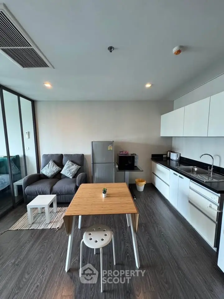 Modern open-layout kitchen and living room with sleek design and cozy seating area.
