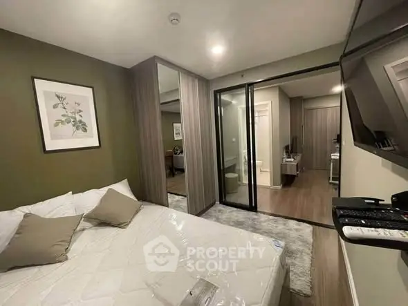 Modern bedroom with mirrored closet and stylish decor in a contemporary apartment.