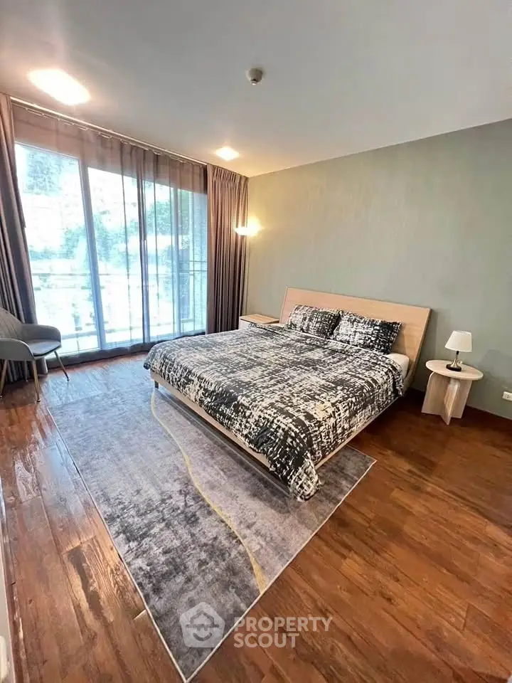 Spacious modern bedroom with large windows and stylish decor in a luxury apartment.
