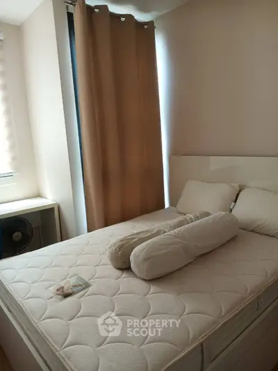 Cozy bedroom with natural light and modern furnishings, perfect for relaxation and comfort.