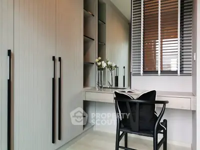 Modern study room with sleek desk and chair, built-in storage, and elegant decor.