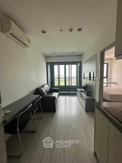 Modern living room with sleek furniture and large windows offering natural light and a view.