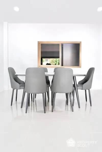 Modern dining area with sleek grey chairs and minimalist decor