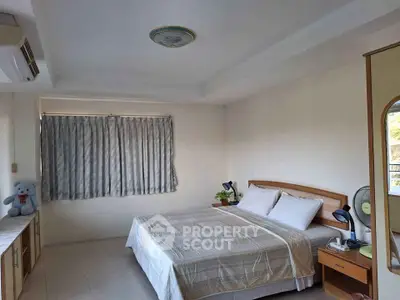 Spacious bedroom with ample natural light, featuring a large bed, air conditioning, and a serene view through the window, perfect for relaxation.
