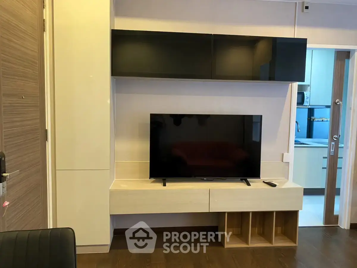 Modern living room with sleek TV unit and open kitchen view