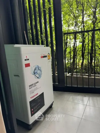 Modern washing machine on a stylish balcony with lush greenery view.