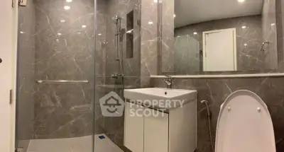 Modern bathroom with sleek marble tiles and glass shower enclosure