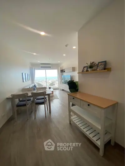Modern living room with ocean view, stylish furniture, and natural light.